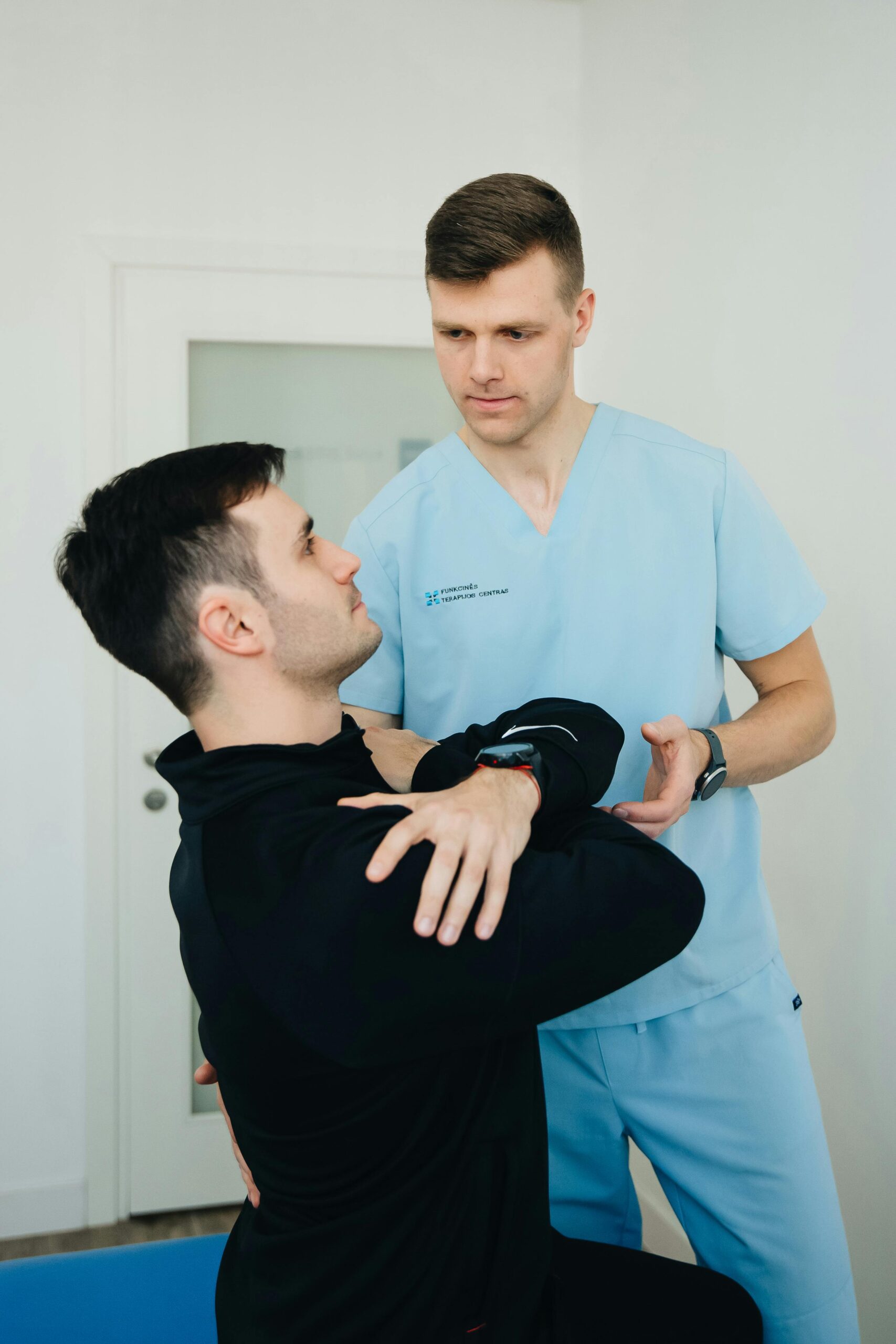 Physiotherapist assists a patient in therapeutic exercises indoors.